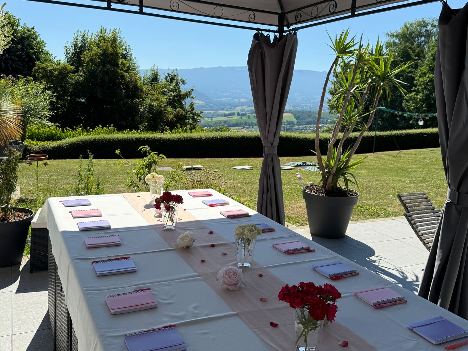 Table dressée sous la pergola de la villa, face à la vallée et aux montagnes