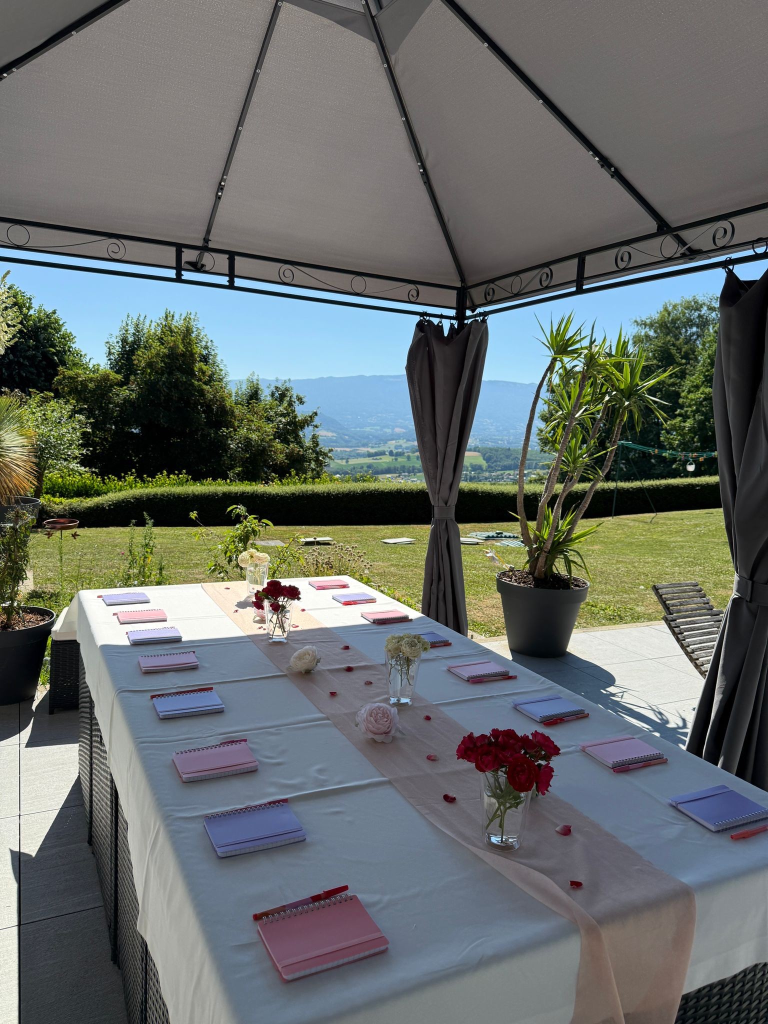 Table de travail dressée sous la tonnelle du jardin de la Villa Gai Moulin, face aux Alpes, team building près d'Annecy
